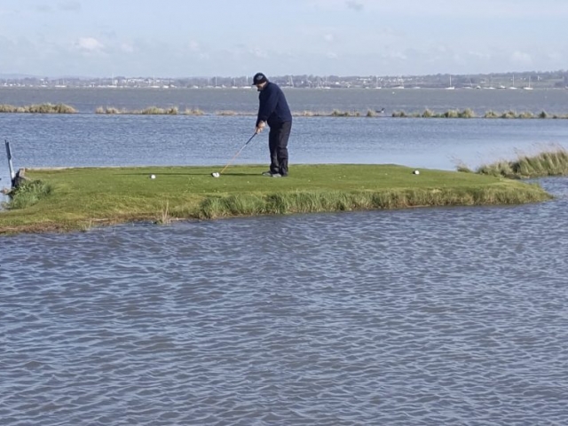 The white 18th tee with a high tide around it